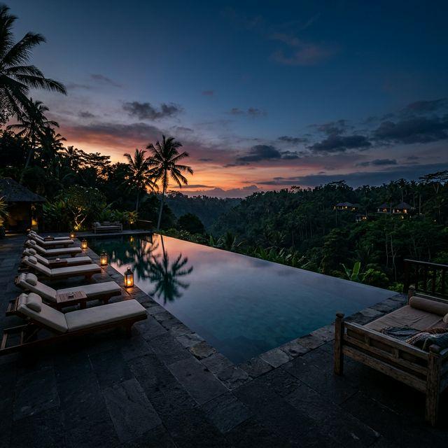 Atmospheric wide shot of a luxurious Bali villa pool glowing at golden hour